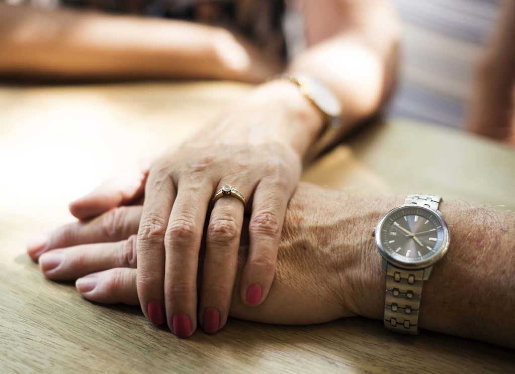 senior holding hands